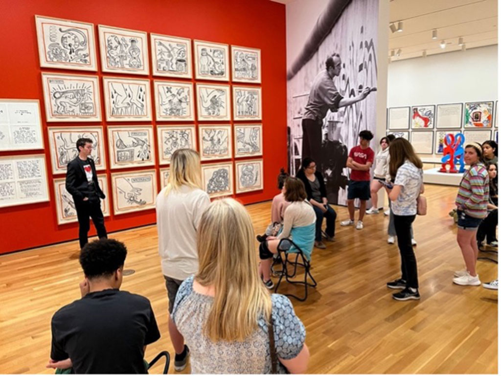 A group of high school students are in an art gallery